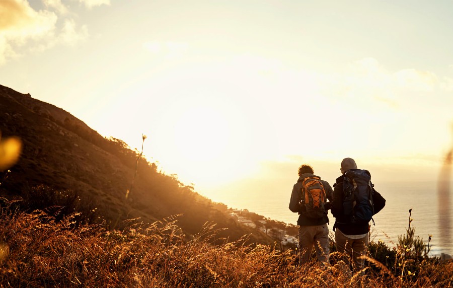 Zwei Wanderer an der Küste während Sonnenuntergang